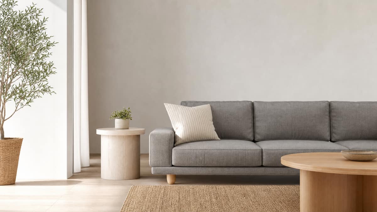 Calm styled living room with a grey sofa, striped cushion and simple side table